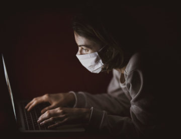 Koronawirus. Kobieta w maseczce i laptop